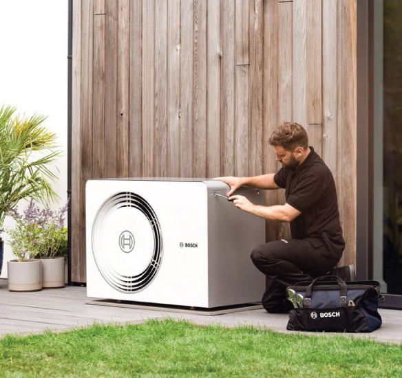 Installer fitting heat pump outside